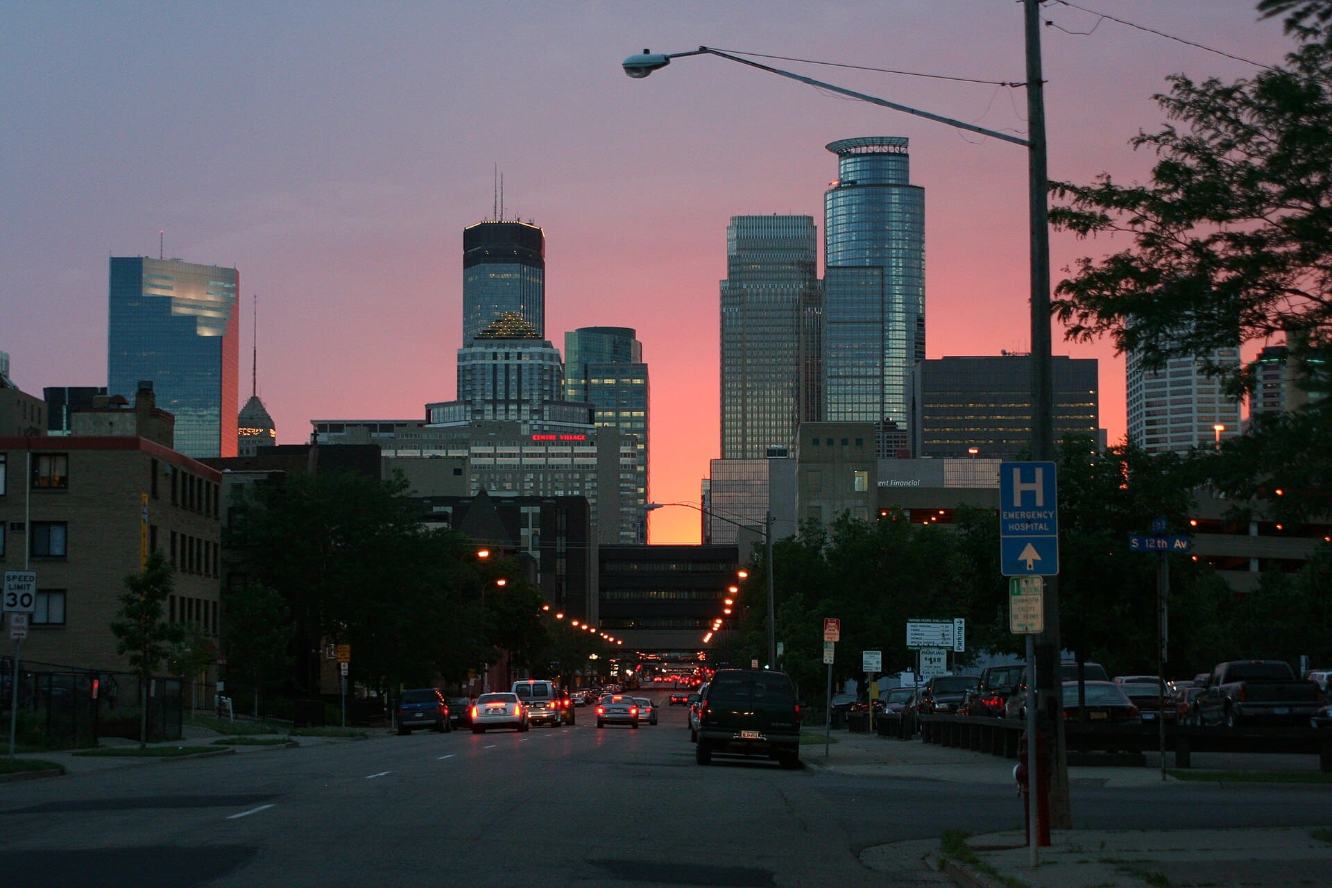 Skyline of Minneapolis, Minnesota with bright sunset behind.
