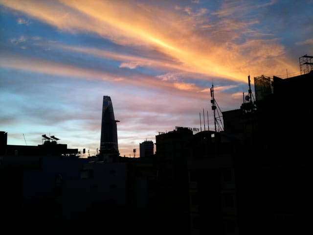 The skyline of Ho Chi Minh City just before sunrise. The Bitexco Financial Tower is silhouetted.