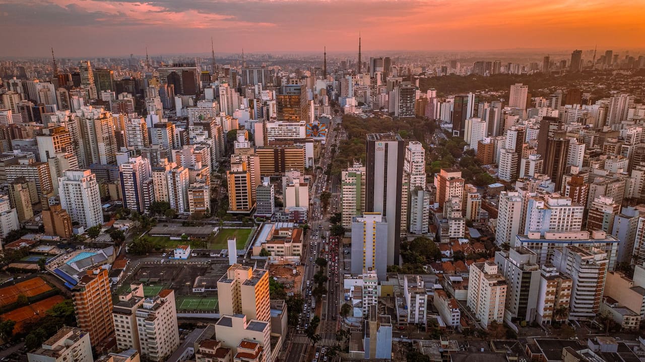 Breathtaking aerial view of São Paulo with skyscrapers under a vibrant sunset sky.