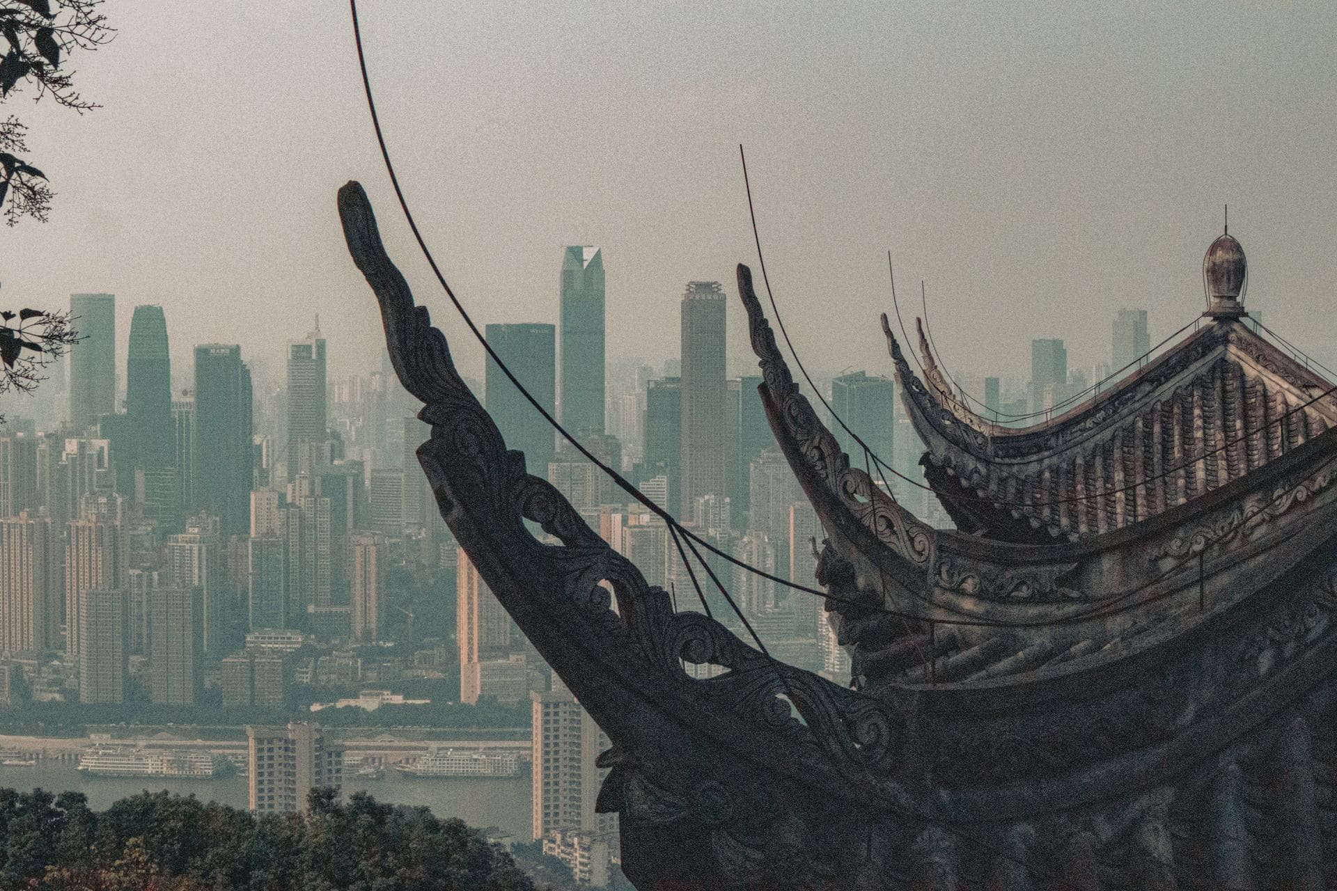 A traditional temple roof contrasts a modern skyline, showcasing architectural diversity.