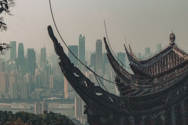 A traditional temple roof contrasts a modern skyline, showcasing architectural diversity.