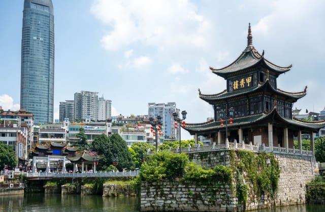 Harmonious blend of traditional Chinese pavilion and modern skyscraper in cityscape.