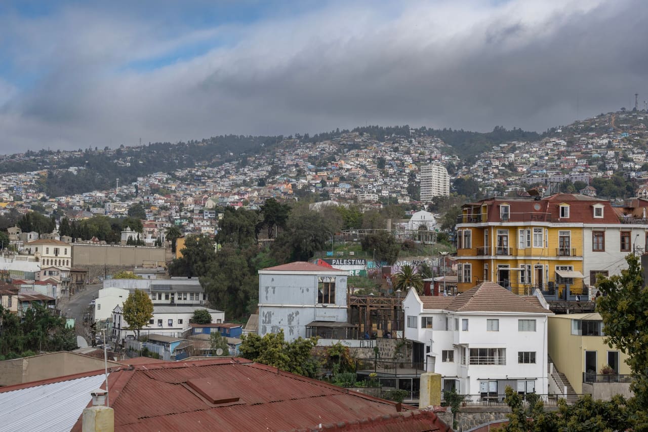 View of vibrant hillside houses in Valparaíso, Chile, under cloudy skies.