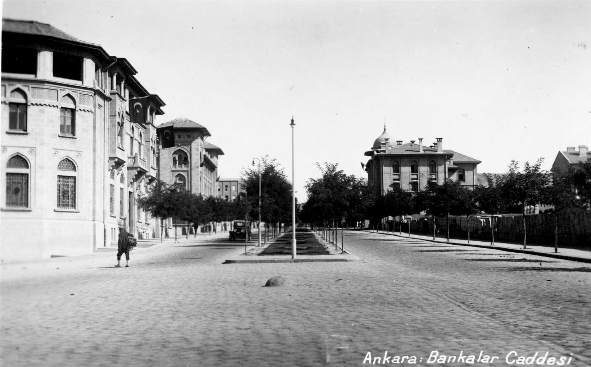 www.archives.saltresearch.org/R/QETRM7R3C38IBCM5LGHKSXI6A... Bankalar Street was the first street to be built in district of Ulus during the construction of the new capitol Ankara. As the original financial district of Ankara, the street was composed of large monumental buildings, mostly built between 1926-1934. The first building to go up in 1926 was the Ottoman Bank, designed by Guilio Mongeri. For the same street Mongeri also designed the İş Bank General Headquarters and Ziraat Bank. Being major examples of the First National Architecture Movement, these buildings stand out for their cratfmanship as well as their use of classical Ottoman forms. Construction contnued with the designs of Clemens Holzmeister in 1930-1934 for the Central Bank and the Bank of Estates and Orphans. Differing from the previous buildings, these two banks have refined classical characteristics. SALT Research, Photography Archive Ulus’ta yer alan Bankalar Caddesi, Ankara’nın başkent ilan edilmesinin ardından yapılaşmanın ilk başladığı yerdir. Başkentin finans bölgesi olması dolayısıyla caddede, 1926-1934 yıllarında yapılmış görkemli binalar yer alır. 1926’da Guilio Mongeri tarafından tasarlanan Osmanlı Bankası ile başlayan yapılaşma, yine Mongeri’nin İş Bankası ve Ziraat Bankası binalarıyla devam eder. Birinci Ulusal Mimarlık akımının tipik birer örneği olan binalar, ince işçiliklerinin yanı sıra klasik Osmanlı biçimlerinin kullanımıyla dikkati çeker. Bunları, 1930-1934 yıllarında mimar Clemens Holzmeister tarafından yapılmış olan Merkez Bankası ile Emlak ve Eytam Bankası binaları izler. Bu binalar, öncekilerden farklı olarak sadeleştirilmiş klasisist özelliklere sahiptir. SALT Araştırma, Fotoğraf Arşivi