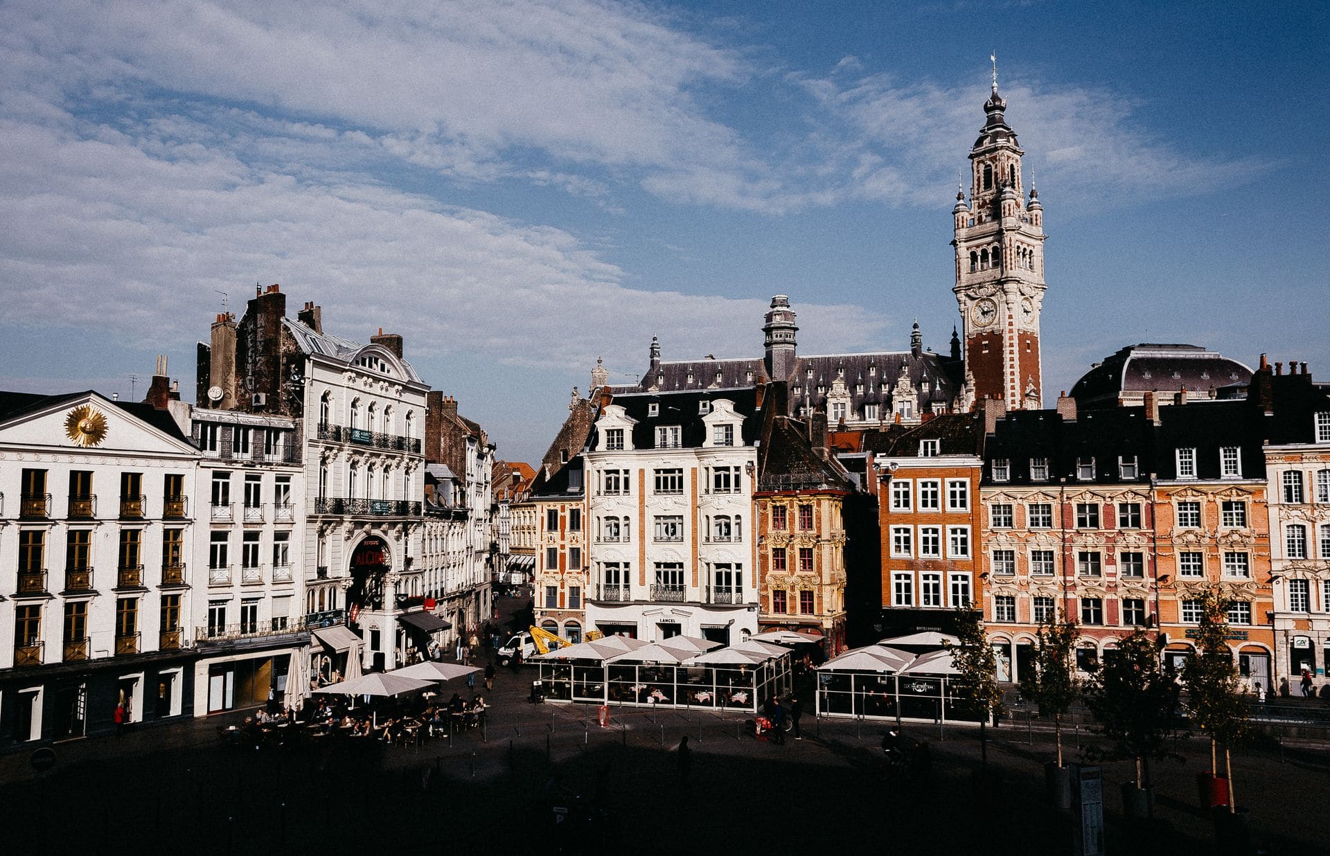 Scenic view of colorful buildings at Lille Grand Place with clear blue sky in daylight.
