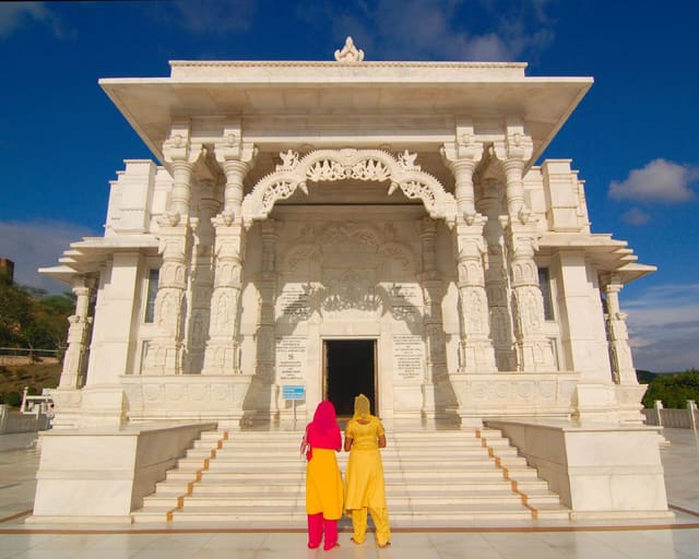 Birla Mandir or the Lakshmi-Narayan Temple, situated just below the Moti Dungari is a modern temple built of white marble on top of a hill, dominating the skyline of south Jaipur. The Birlas (industrialists who have also built several temples in India) built this temple. The temple has been constructed in white marble and has three domes, each portraying the different approaches to religion. The presiding deities here are Vishnu (One of the Hindu Trilogy Gods) called Narayan and his consort Lakshmi Goddess of wealth and good fortune. The temple is built is white in marble and exterior has carved sculptures of various mythological themes and images of saints. The interior has large panel in marble of mythological proceedings. The images of the deities are placed in the sanctum sanctorum. Built on raised ground, it is surrounded by large lush green gardens. Birla Mandir is sheer poetry in stone was built over a span of ten years by the Birla Foundationprayer