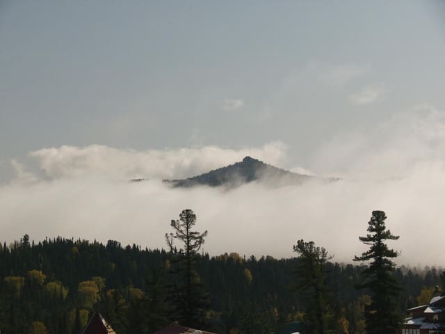 The skyline was all covered with clouds and only some peaks raised above the white veil.