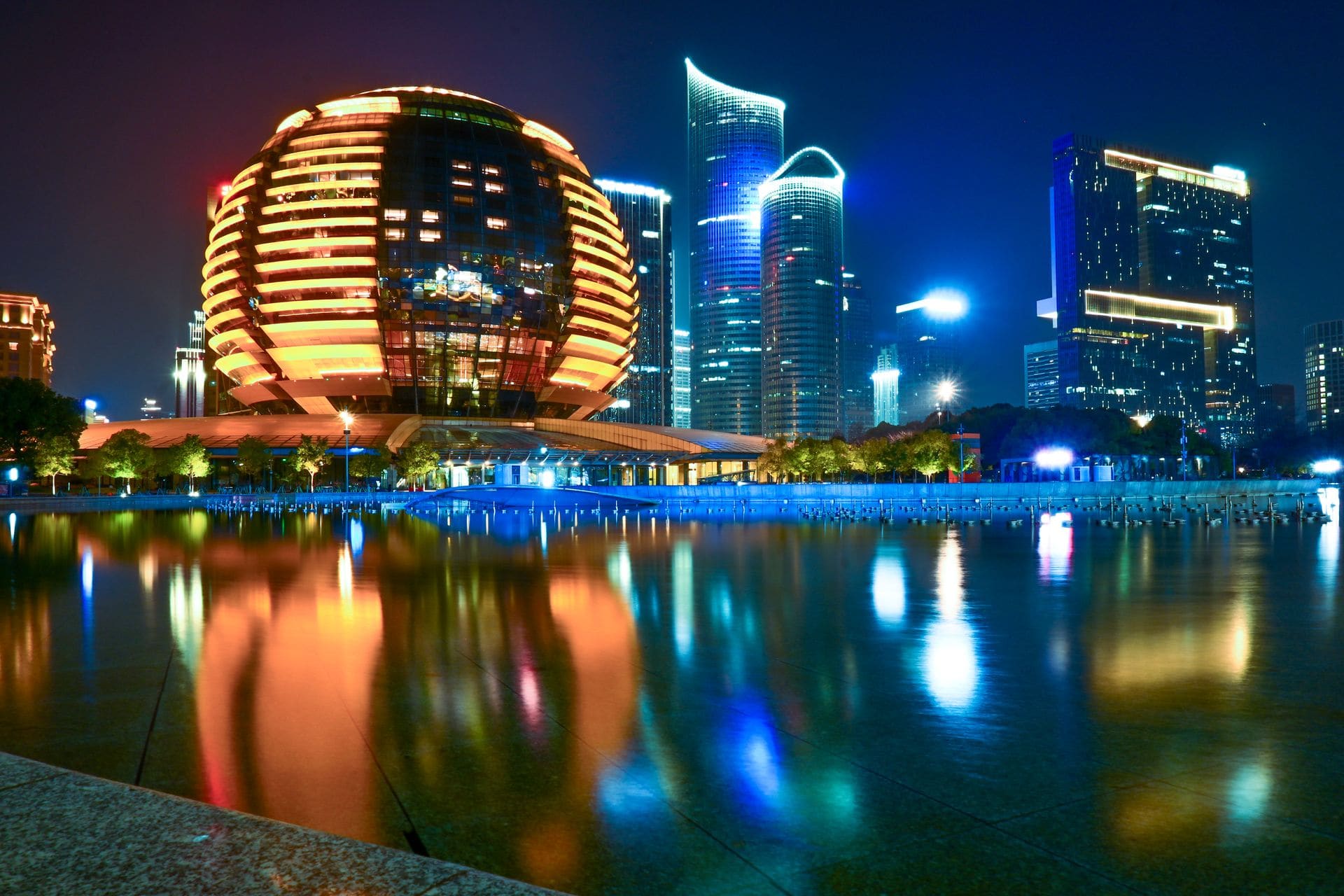 Stunning reflection of Hangzhou's illuminated skyline featuring modern architecture during the night.