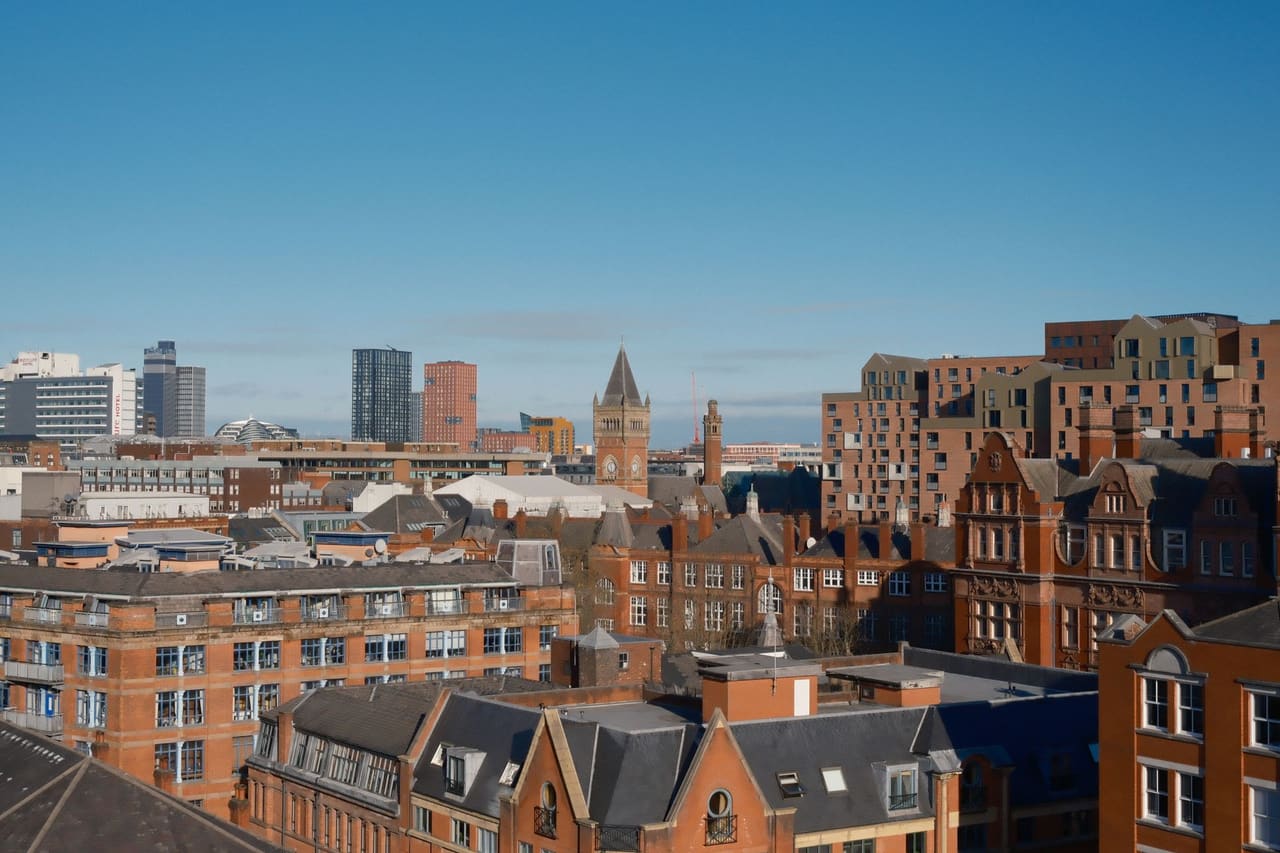 A vibrant view of Manchester showcasing modern and classic architecture under a clear sky.