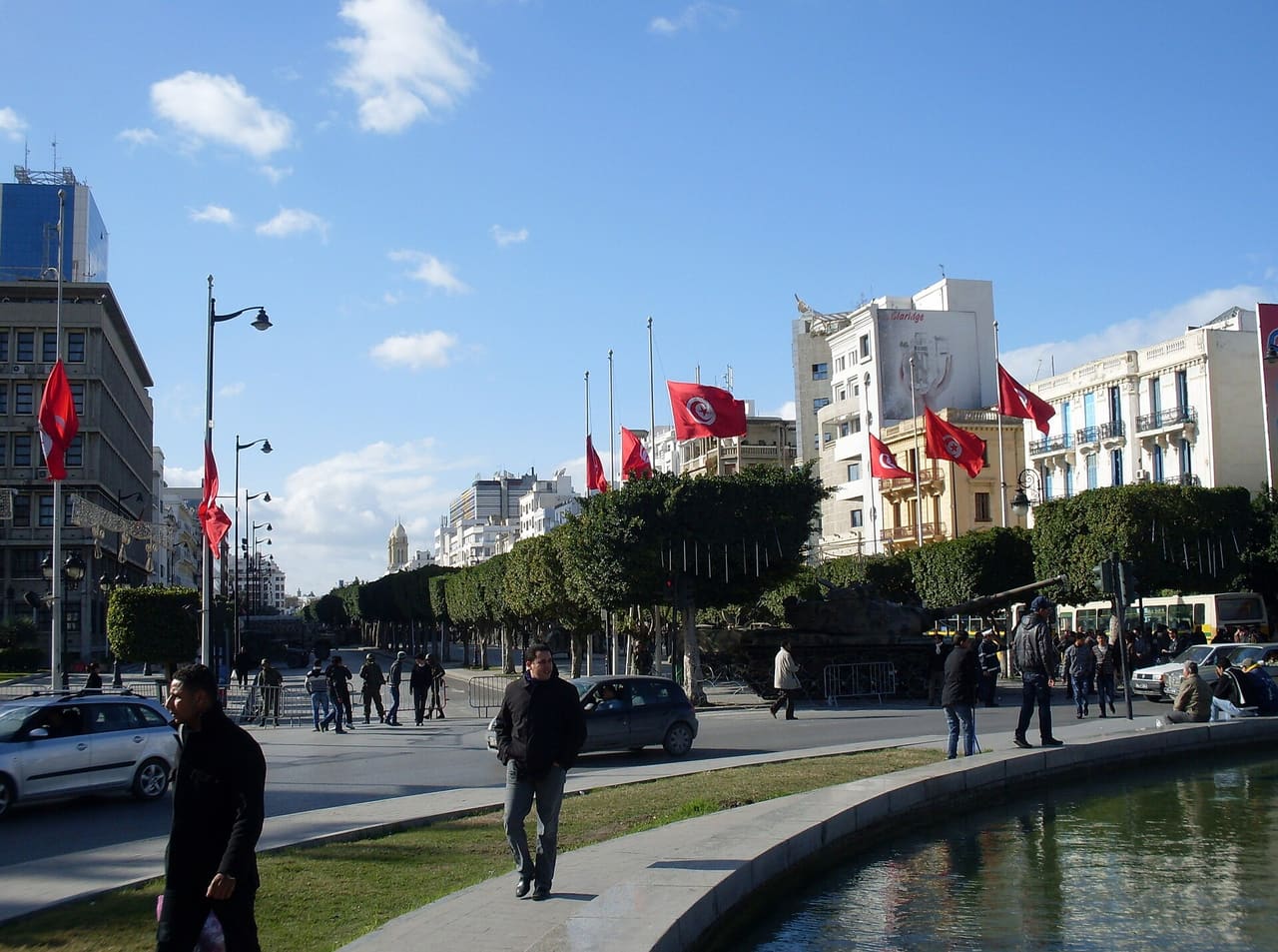National flags flying at half staff on the Habib Bourguiba Lane (14th of January Square) following the death of martyrs of the Jasmine Revolution in Tunisia in 2011. The Cathedral of Tunis, on the Habib Bourguiba Lane, can be seen on the skyline