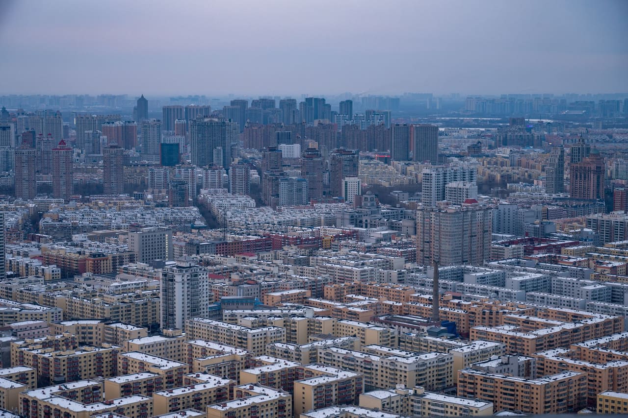 Expansive view of Harbin city skyline under a winter sky, showcasing dense urban architecture.