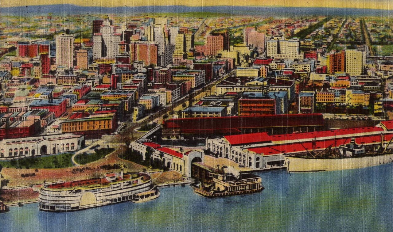 Postcard of New Orleans. Aerial view from over the river near the foot of Canal Street looking lakewards. The Canal Street Ferry at the Canal Wharf visible at bottom center. To right is the since demolished Iberville Street Wharf, beyond it the old Louisville & Nashville Station, one of the city's major railway terminals. To left on the river is a paddle wheel ship. Canal Street seen running diagonally, looking like it extends to Lake Pontchartrain-- it looks to me like the artist who modified the photo to add false color has moved the lakefront in a bit closer to the front of the city.