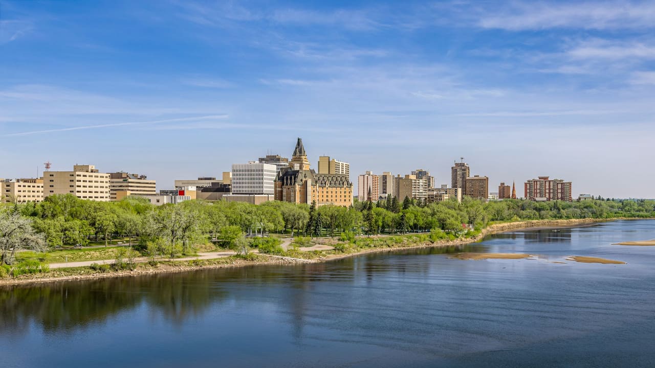 A beautiful spring view of Saskatoon cityscape with a river and reflections.