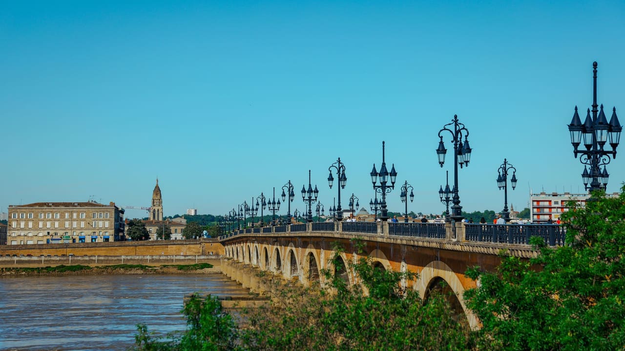 Elegant view of Pont de Pierre bridge in Bordeaux, France on a sunny day.