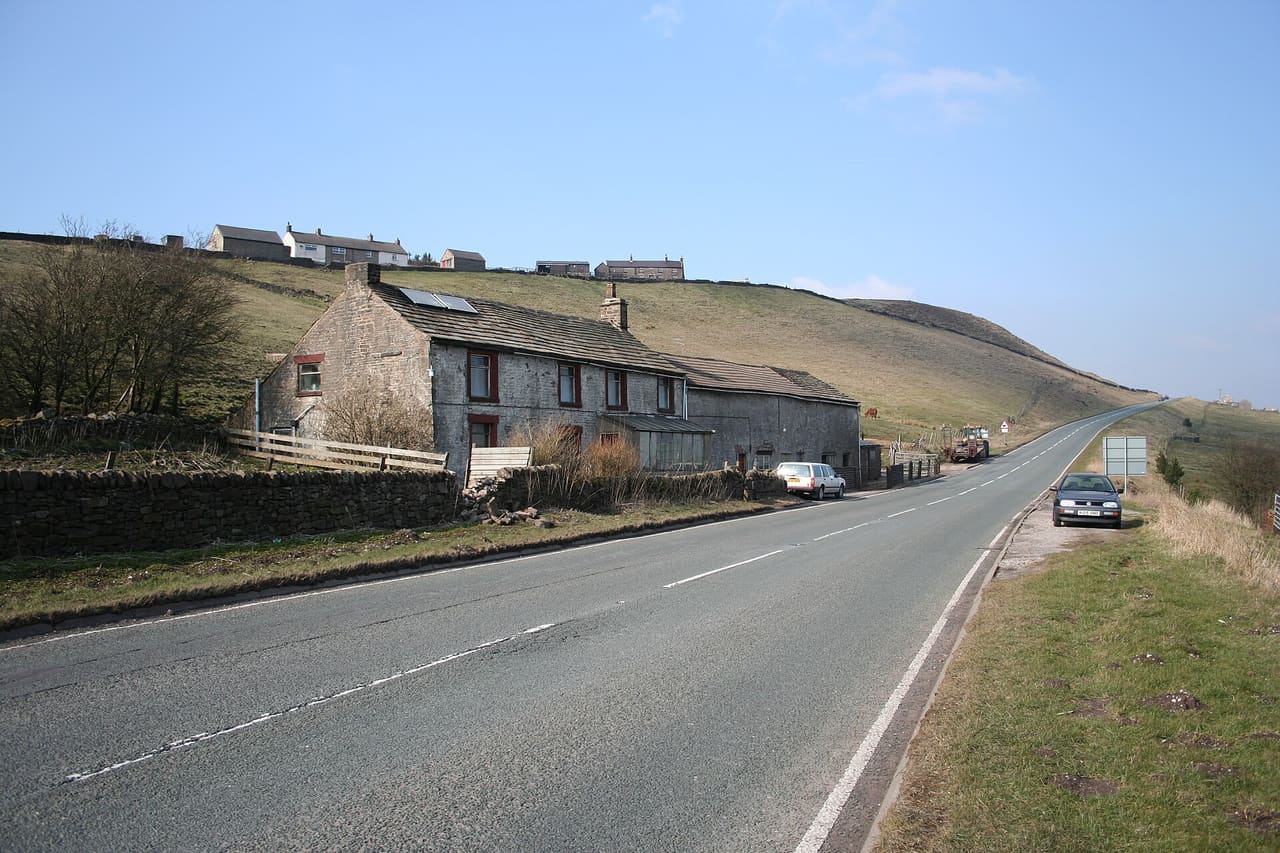 Dove Head Farm and A53 Looking towards Buxton on the A53. The source of the River Dove lies below this farm (on the right-hand side of the road). On the skyline are the cottages of Axe Edge End.