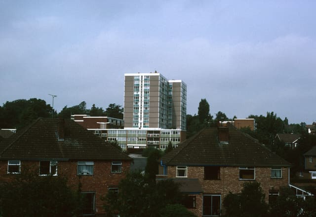 Multi-storey block details: one 11-storey block containing 81 dwellings; Multi-storey block name(s): Russell House; Image detail: View of Russell House from Holyhead Road Original Commissioning Authority: Wednesbury Municipal Borough Council; Image taken: 1987;Context: Tower Block UK is a project supported by the Heritage Lottery Fund, bringing together public engagement and an openly-licensed image archive in an attempt to emphasise the social and architectural importance of tower blocks, and to frame multi-storey social housing as a coherent and accessible nationwide heritage. The Tower Block UK image archive is a searchable database of around 4,000 images of every multi-storey social housing development built in the UK. The photographs were largely taken in the 1980s by Miles Glendinning and are made available here for public use. As many of the blocks documented and photographed have since been demolished, the archive functions in part as a repository of information on an important aspect of UK heritage that is now vanishing. The archive itself catalogues multi-storey blocks as part of the developments within which they were initially commissioned and built. It gives details of notable dates, such as when local authorities approved the developments and when construction began or finished. Alongside this, the archive provides information on the local authorities, architects, and other agents involved in the processes of commissioning, designing, and constructing mass social housing. While the most historically 'accurate' identification labels in the database are the original overall development or project names, the archive also contains details of the individual blocks built.