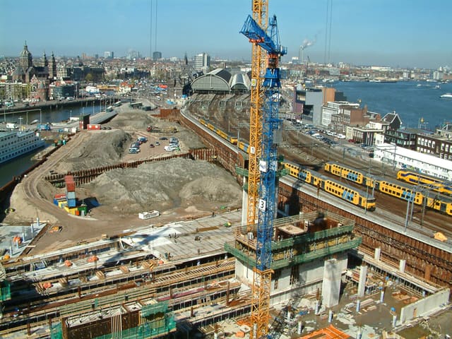2005 - photo of wide city view over the earthworks and construction sites in the area Oosterdijkseiland, along the water Oosterdok in Amsterdam city, including high building-cranes. Free download image CC0 in high resolution photo, by Dutch photographer Fons Heijnsbroek.